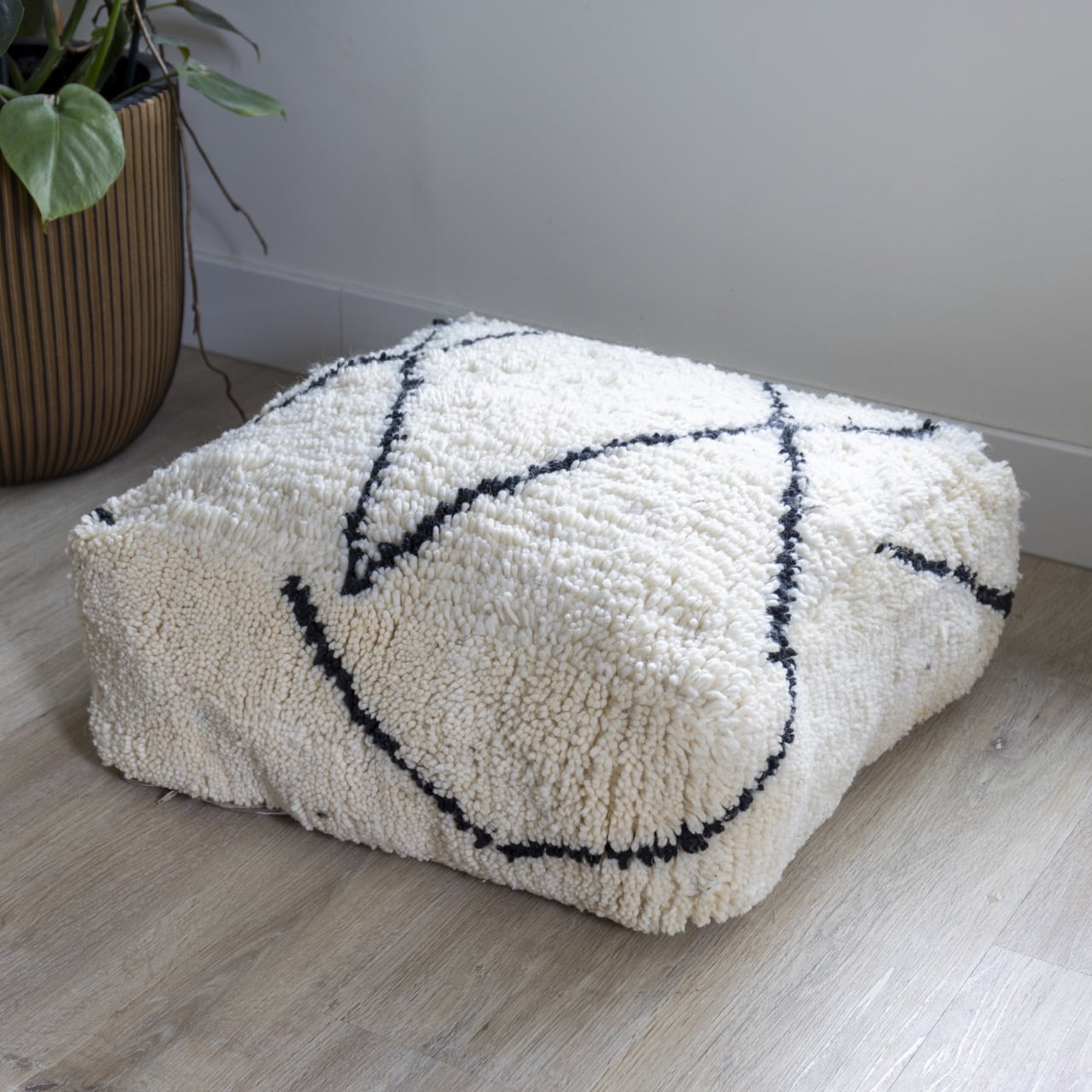 Poef met zwarte lijnen handgemaakt van wol